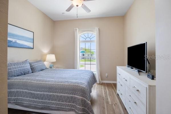 6235 SW 95th Pl, Ocala, FL 34476 - bedroom featuring light wood-style flooring, baseboards, and a ceiling fan