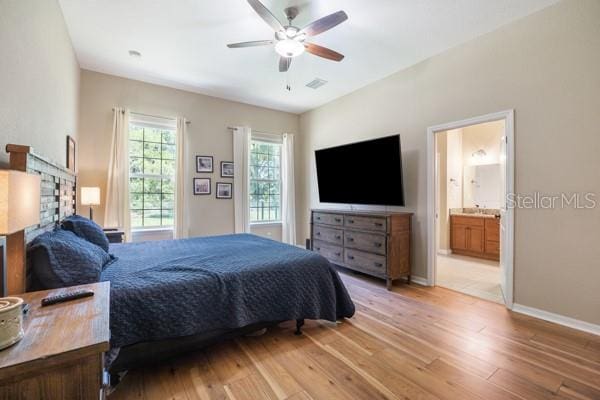 6235 SW 95th Pl, Ocala, FL 34476 - bedroom with light wood-type flooring, baseboards, connected bathroom, and ceiling fan