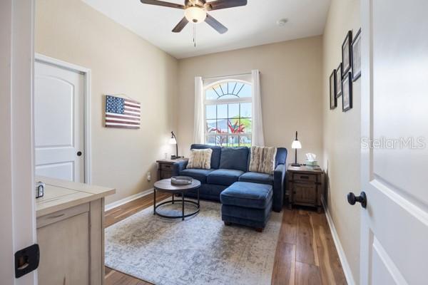 6235 SW 95th Pl, Ocala, FL 34476 - living area featuring wood finished floors, a ceiling fan, and baseboards