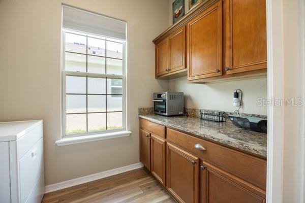 6235 SW 95th Pl, Ocala, FL 34476 - laundry room featuring cabinet space, baseboards, and light wood finished floors
