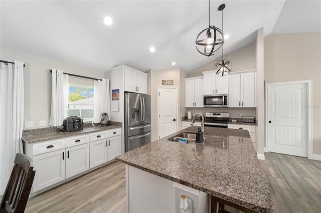 7442 SW 129th Ln, Ocala, FL 34473 - kitchen with appliances with stainless steel finishes, a sink, lofted ceiling, light wood-style floors, and white cabinetry