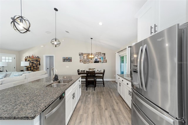 7442 SW 129th Ln, Ocala, FL 34473 - kitchen featuring stainless steel appliances, a sink, vaulted ceiling, light wood-type flooring, and white cabinets