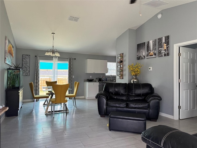 1100 NW 126th Ln, Citra, FL 32113 - living area featuring lofted ceiling, baseboards, and a chandelier
