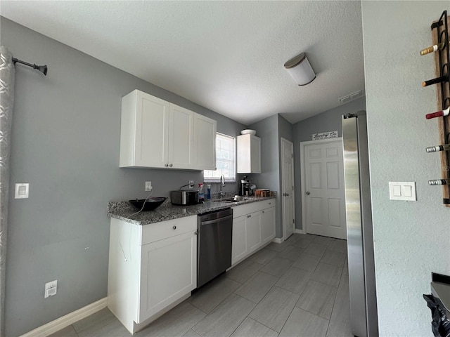 1100 NW 126th Ln, Citra, FL 32113 - kitchen with appliances with stainless steel finishes, a sink, white cabinets, stone countertops, and a textured ceiling