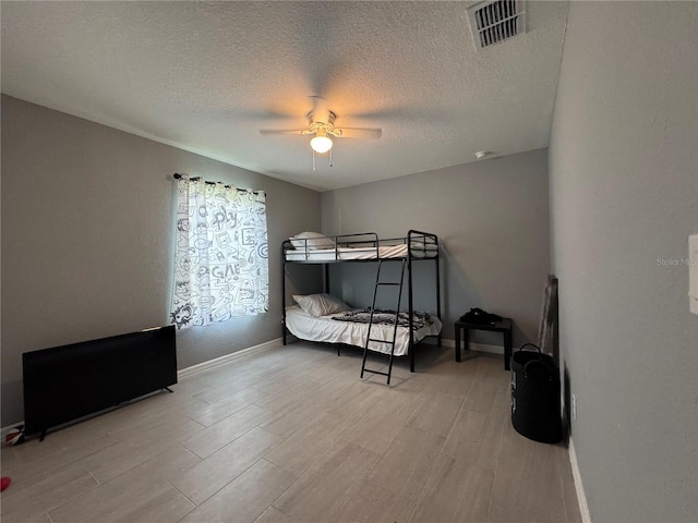 1100 NW 126th Ln, Citra, FL 32113 - bedroom with wood finished floors, baseboards, a textured ceiling, and a ceiling fan