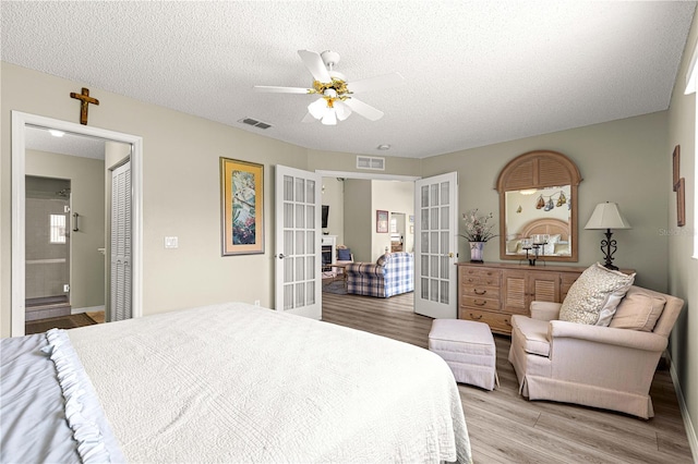 9266 SW 91st Cir, Ocala, FL 34481 - bedroom featuring french doors, light wood-type flooring, a textured ceiling, and ceiling fan