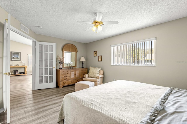 9266 SW 91st Cir, Ocala, FL 34481 - bedroom featuring light wood-style floors, a textured ceiling, and a ceiling fan