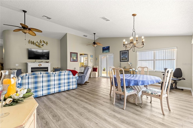9266 SW 91st Cir, Ocala, FL 34481 - dining area featuring a ceiling fan, lofted ceiling, light wood finished floors, a fireplace, and a chandelier