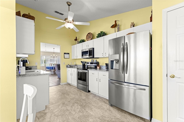 9266 SW 91st Cir, Ocala, FL 34481 - kitchen with appliances with stainless steel finishes, ceiling fan, a sink, white cabinets, and light stone countertops