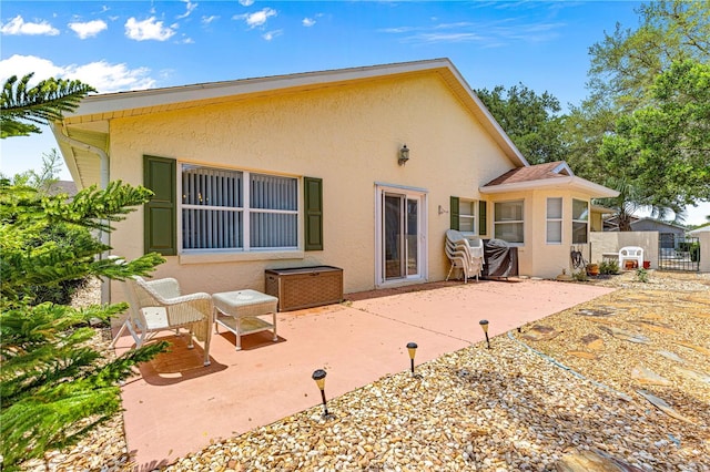 9266 SW 91st Cir, Ocala, FL 34481 - rear view of house with stucco siding and a patio
