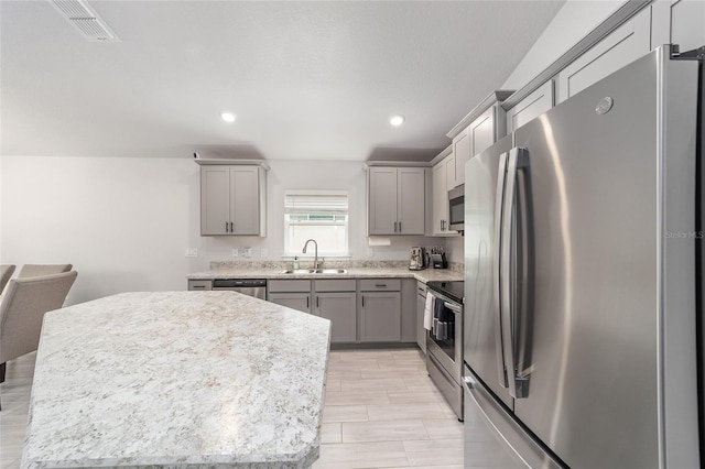 181 NW 45th Loop, Ocala, FL 34475 - kitchen with stainless steel appliances, gray cabinets, a sink, recessed lighting, and a kitchen island