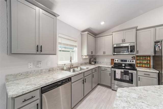 181 NW 45th Loop, Ocala, FL 34475 - kitchen with stainless steel appliances, a sink, gray cabinets, vaulted ceiling, and recessed lighting