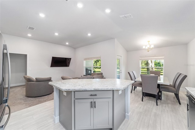 181 NW 45th Loop, Ocala, FL 34475 - kitchen featuring gray cabinetry, a chandelier, freestanding refrigerator, a kitchen island, and lofted ceiling