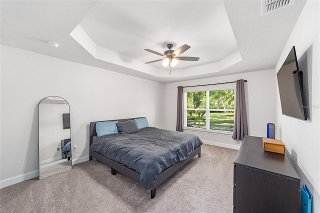 181 NW 45th Loop, Ocala, FL 34475 - bedroom with a tray ceiling, light carpet, baseboards, and a ceiling fan