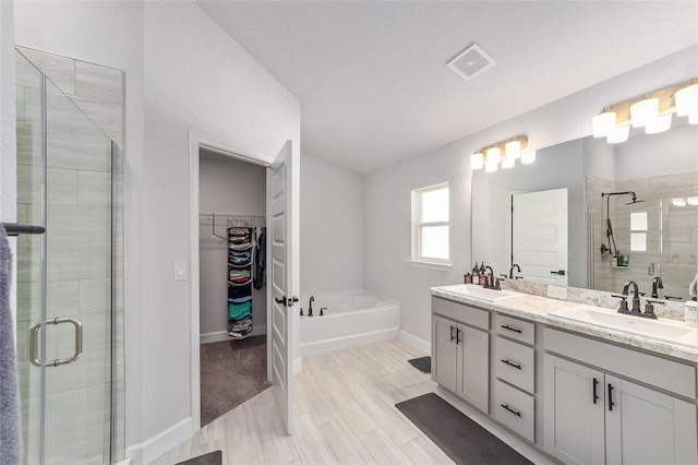 181 NW 45th Loop, Ocala, FL 34475 - bathroom featuring a shower stall, double vanity, a garden tub, and a spacious closet