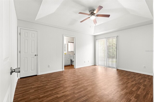 10016 SW 62nd Cir, Ocala, FL 34476 - unfurnished bedroom with wood finished floors, a tray ceiling, baseboards, a ceiling fan, and connected bathroom
