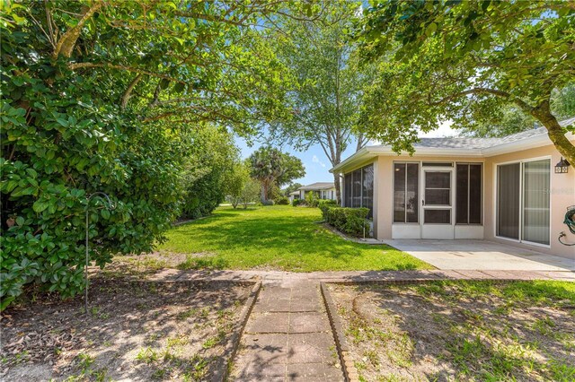 10016 SW 62nd Cir, Ocala, FL 34476 - view of green lawn with a sunroom and a patio