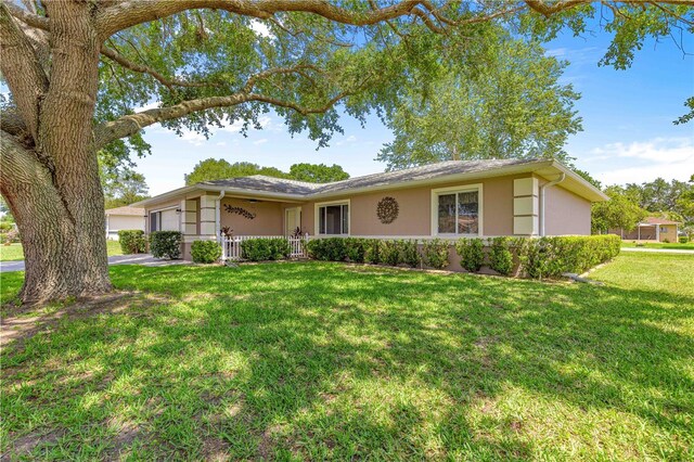 10016 SW 62nd Cir, Ocala, FL 34476 - single story home with stucco siding, an attached garage, and a front lawn