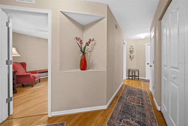 11147 SW 53rd Cir, Ocala, FL 34476 - hall featuring wood finished floors, baseboards, and a baseboard heating unit