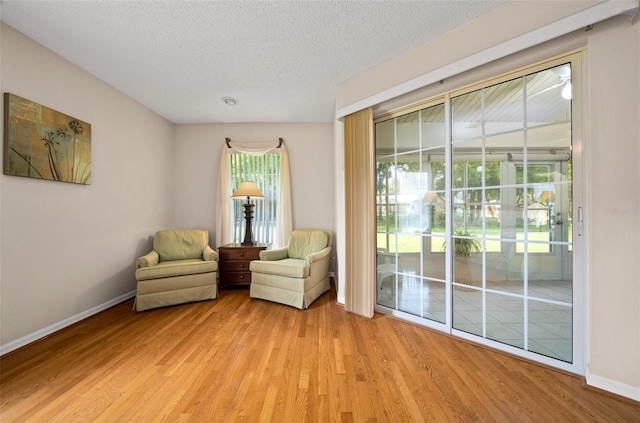 11147 SW 53rd Cir, Ocala, FL 34476 - sitting room featuring light wood-type flooring, baseboards, and a textured ceiling