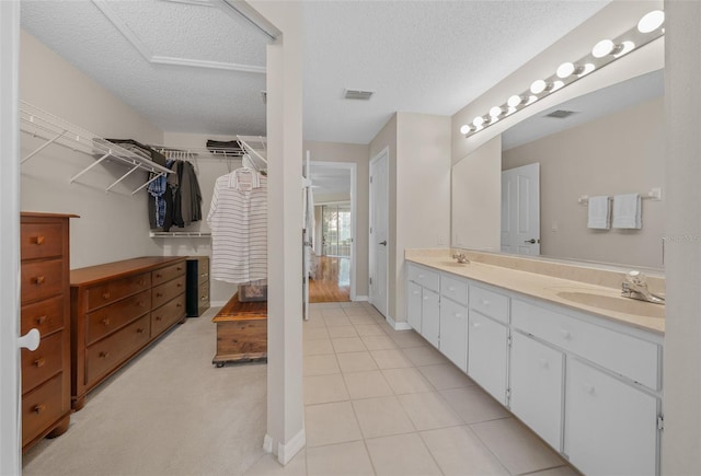 11147 SW 53rd Cir, Ocala, FL 34476 - full bathroom with a textured ceiling, double vanity, tile patterned floors, a walk in closet, and baseboards