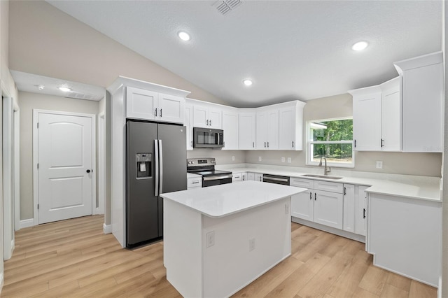 8293 SE 158th St, Summerfield, FL 34491 - kitchen with appliances with stainless steel finishes, a sink, light wood finished floors, white cabinets, and vaulted ceiling