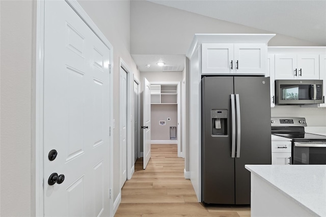 8293 SE 158th St, Summerfield, FL 34491 - kitchen featuring appliances with stainless steel finishes, white cabinets, light wood-type flooring, lofted ceiling, and light countertops