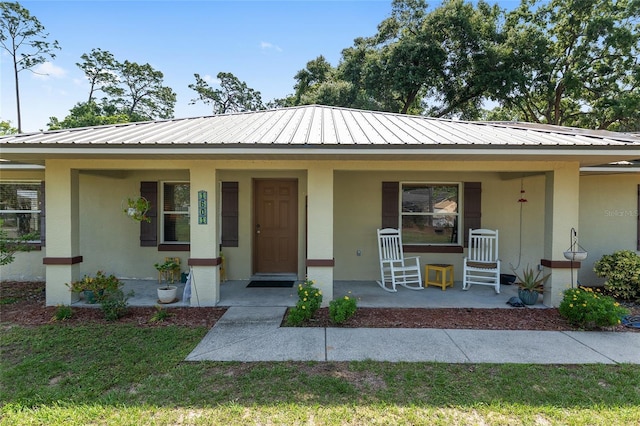 1601 NE 47th Ct, Ocala, FL 34470 - view of front of home with covered porch, stucco siding, and metal roof