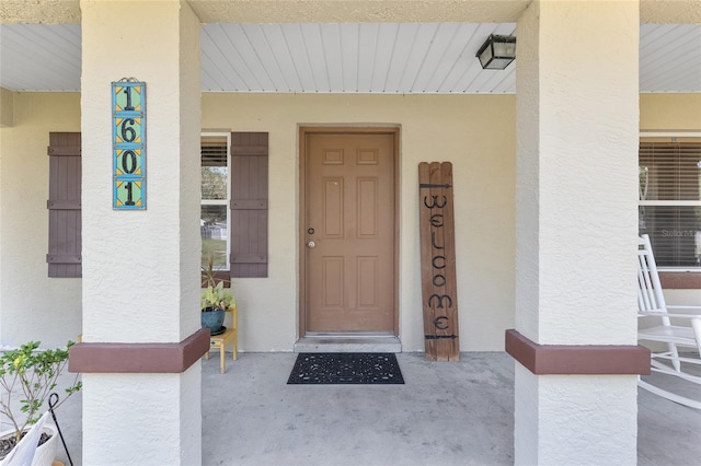1601 NE 47th Ct, Ocala, FL 34470 - view of exterior entry featuring stucco siding and a porch