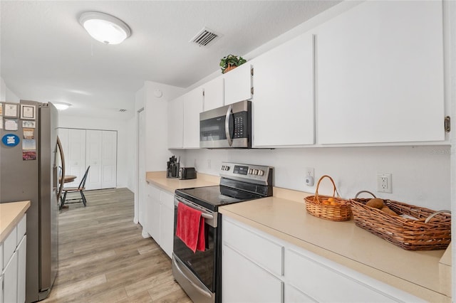 1601 NE 47th Ct, Ocala, FL 34470 - kitchen featuring stainless steel appliances, light wood-type flooring, white cabinetry, and light countertops