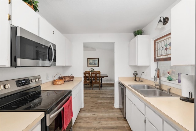 1601 NE 47th Ct, Ocala, FL 34470 - kitchen with stainless steel appliances, a sink, light wood-style flooring, and light countertops