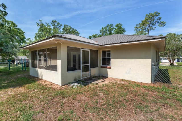 1601 NE 47th Ct, Ocala, FL 34470 - back of property featuring stucco siding, a sunroom, and metal roof