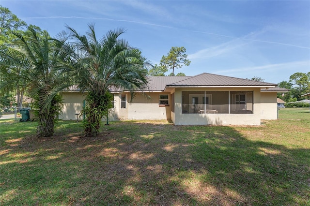 1601 NE 47th Ct, Ocala, FL 34470 - rear view of house with stucco siding, a yard, metal roof, and a sunroom