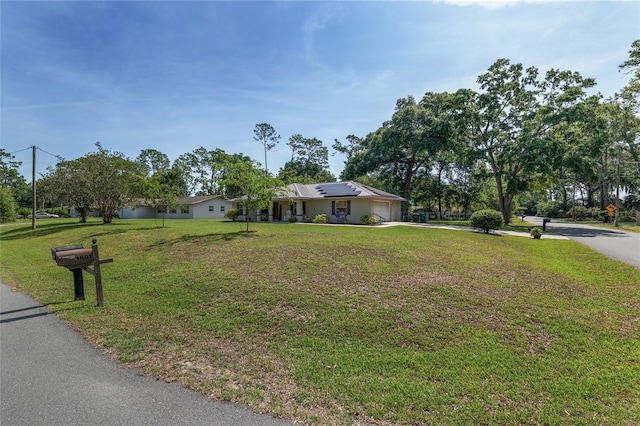 1601 NE 47th Ct, Ocala, FL 34470 - ranch-style home featuring a garage, solar panels, driveway, and a front lawn