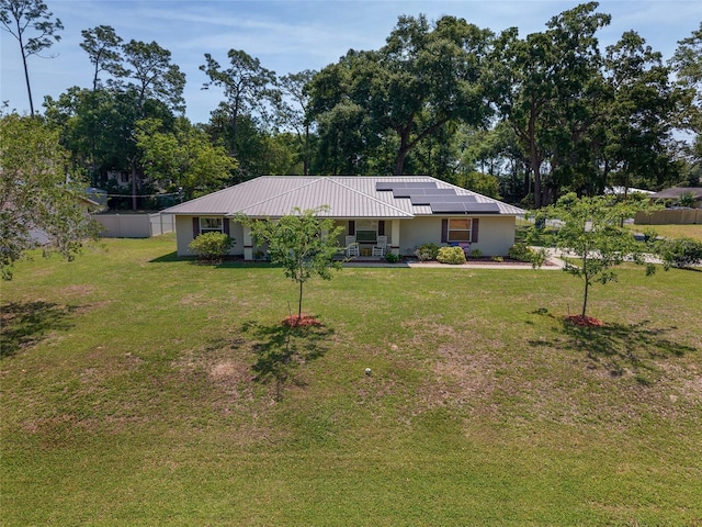 1601 NE 47th Ct, Ocala, FL 34470 - ranch-style home featuring roof mounted solar panels, a front lawn, stucco siding, and metal roof