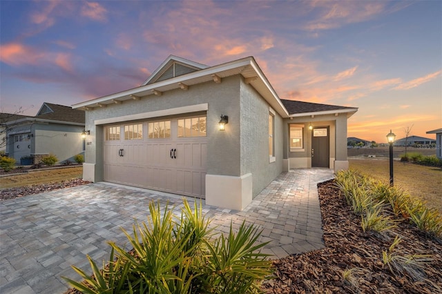 10277 SW 96th Loop, Ocala, FL 34481 - view of front facade featuring a garage, stucco siding, and decorative driveway