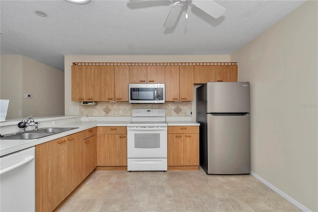 2608 Botello Ave, The Villages, FL 32162 - kitchen with appliances with stainless steel finishes, a sink, light countertops, ceiling fan, and decorative backsplash