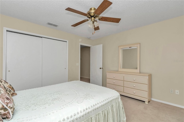 2608 Botello Ave, The Villages, FL 32162 - bedroom featuring a closet, light colored carpet, baseboards, ceiling fan, and a textured ceiling