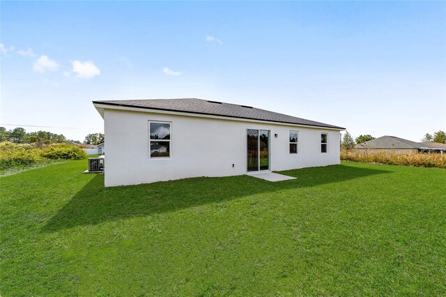 5141 SW 157th St, Ocala, FL 34473 - rear view of property with a lawn and stucco siding