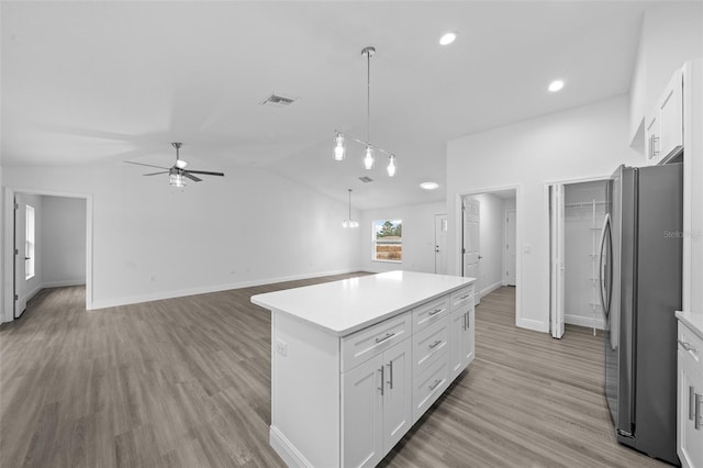 7 Walnut Pl, Ocala, FL 34480 - kitchen with freestanding refrigerator, a ceiling fan, white cabinets, light countertops, and vaulted ceiling