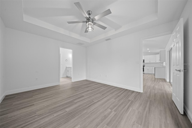 7 Walnut Pl, Ocala, FL 34480 - empty room featuring a raised ceiling, ceiling fan, light wood-style floors, and baseboards