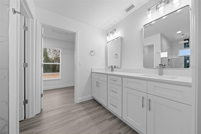 7 Walnut Pl, Ocala, FL 34480 - bathroom with a marble finish shower, double vanity, wood finished floors, and baseboards