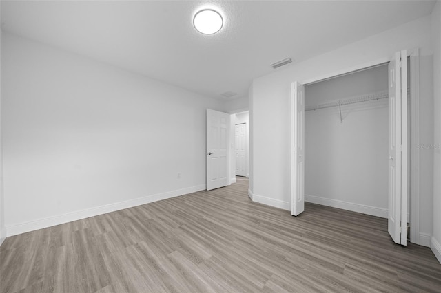 7 Walnut Pl, Ocala, FL 34480 - unfurnished bedroom with wood finished floors, a closet, and baseboards