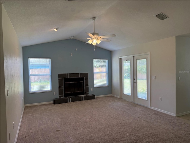 206 SE 8th Ave, Williston, FL 32696 - unfurnished living room with carpet flooring, ceiling fan, vaulted ceiling, a tiled fireplace, and french doors