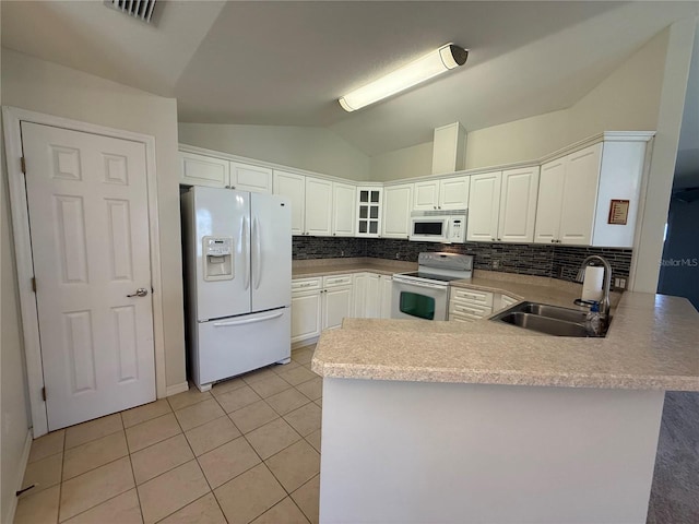 206 SE 8th Ave, Williston, FL 32696 - kitchen with white appliances, a peninsula, vaulted ceiling, light tile patterned floors, and backsplash