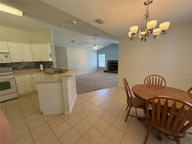 206 SE 8th Ave, Williston, FL 32696 - kitchen with white appliances, vaulted ceiling, a peninsula, light tile patterned floors, and a chandelier