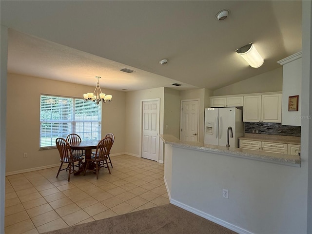 206 SE 8th Ave, Williston, FL 32696 - kitchen featuring white refrigerator with ice dispenser, a chandelier, backsplash, a peninsula, and white cabinetry