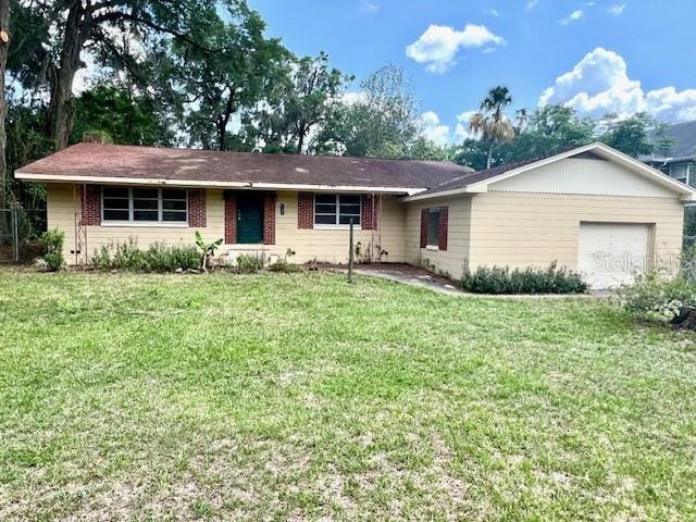 2220 NE 3rd St, Ocala, FL 34470 - ranch-style home featuring a front lawn, an attached garage, and brick siding