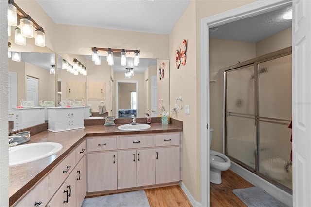 10468 S Drew Bryant Cir, Floral City, FL 34436 - bathroom with a stall shower, wood finished floors, double vanity, and toilet