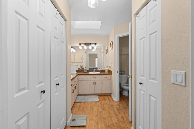 10468 S Drew Bryant Cir, Floral City, FL 34436 - bathroom with a closet, vanity, toilet, wood finished floors, and a skylight
